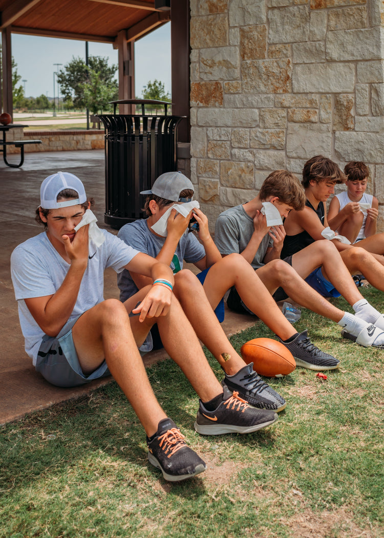 Teen athletes using Wash Yo Self face and body wipes after practice